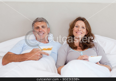To use this stock image in your creative project, please select the size you need over to the right and click the "Add to Cart" button.
Your downloaded image will come with the Cutcaster watermark removed so don’t worry about the watermark you see on this page. Couple eating cereals in bed stock photo, Mature couple eating cereals in bed by Wavebreak Media