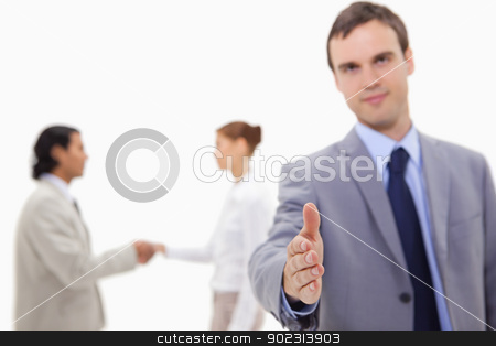 To use this stock image in your creative project, please select the size you need over to the right and click the "Add to Cart" button.
Your downloaded image will come with the Cutcaster watermark removed so don’t worry about the watermark you see on this page. Businessman offering hand with hand shaking colleagues behind hi stock photo, Businessman offering hand with hand shaking colleagues behind him against a white background by Wavebreak Media