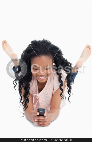 To use this stock image in your creative project, please select the size you need over to the right and click the "Add to Cart" button.
Your downloaded image will come with the Cutcaster watermark removed so don’t worry about the watermark you see on this page. Front view shot of a woman lying on the floor texting off her mo stock photo, A front view shot of a woman lying on the floor and texting off her mobile phone against a white background by Wavebreak Media