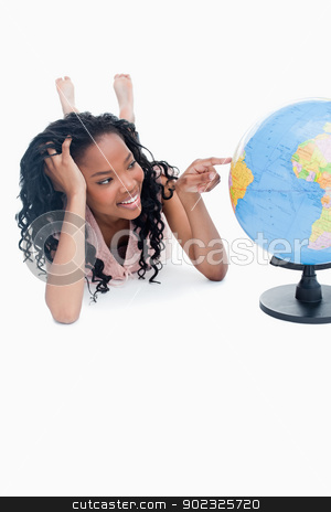 To use this stock image in your creative project, please select the size you need over to the right and click the "Add to Cart" button.
Your downloaded image will come with the Cutcaster watermark removed so don’t worry about the watermark you see on this page. A young girl lying on the floor is pointing at a globe stock photo, A young smiling girl is lying on the floor pointing at a globe against a white background by Wavebreak Media