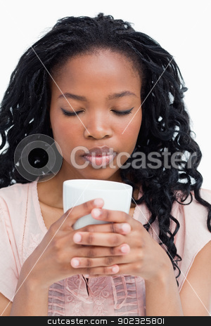 To use this stock image in your creative project, please select the size you need over to the right and click the "Add to Cart" button.
Your downloaded image will come with the Cutcaster watermark removed so don’t worry about the watermark you see on this page. A young woman with her eyes closed is smelling coffee out of a c stock photo, A young woman has her eyes closed and is smelling coffee out of a cup she is holding by Wavebreak Media
