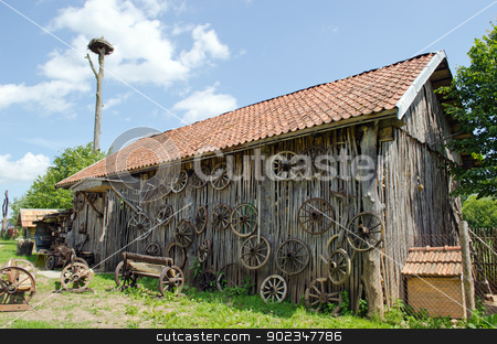 To use this stock image in your creative project, please select the size you need over to the right and click the "Add to Cart" button.
Your downloaded image will come with the Cutcaster watermark removed so don’t worry about the watermark you see on this page. retro carriage wheel barn house bench stork nest stock photo, retro carriage wheel hang on rural barn house. wooden benches. stork nest on top. by sauletas