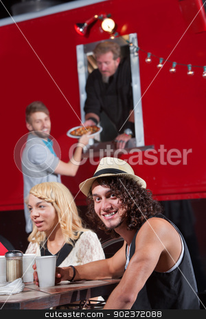 To use this stock image in your creative project, please select the size you need over to the right and click the "Add to Cart" button.
Your downloaded image will come with the Cutcaster watermark removed so don’t worry about the watermark you see on this page. Smiling Man with Friends at Food Truck stock photo, Caucasian male at table with friends ordering pizza by Scott Griessel