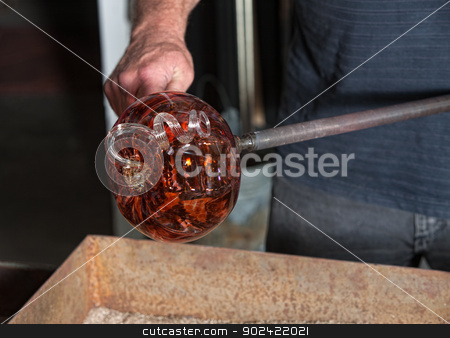 To use this stock image in your creative project, please select the size you need over to the right and click the "Add to Cart" button.
Your downloaded image will come with the Cutcaster watermark removed so don’t worry about the watermark you see on this page. Fancy Glass Pumpkin Artwork stock photo, Worker holding fancy glass pumpkin vase with iron tool by Scott Griessel