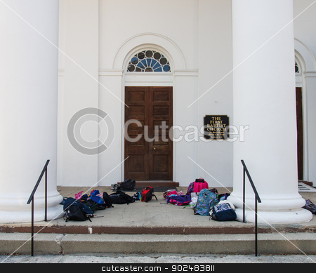 To use this stock image in your creative project, please select the size you need over to the right and click the "Add to Cart" button.
Your downloaded image will come with the Cutcaster watermark removed so don’t worry about the watermark you see on this page. First Baptist Church with Bags stock photo, Entrance to Old Baptist Church with Children's backpacks and book bags by Darryl Brooks