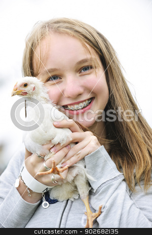 To use this stock image in your creative project, please select the size you need over to the right and click the "Add to Cart" button.
Your downloaded image will come with the Cutcaster watermark removed so don’t worry about the watermark you see on this page. Teenage girl holding chicken stock photo, Smiling teenage girl with braces holding young chicken by Elena Elisseeva