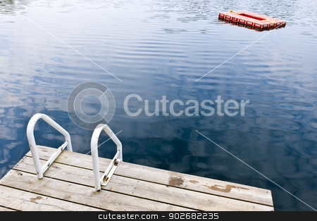 To use this stock image in your creative project, please select the size you need over to the right and click the "Add to Cart" button.
Your downloaded image will come with the Cutcaster watermark removed so don’t worry about the watermark you see on this page. Dock on calm summer lake stock photo, Dock and ladder on calm summer lake with diving platform in Ontario Canada by Elena Elisseeva