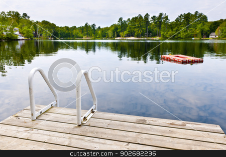 To use this stock image in your creative project, please select the size you need over to the right and click the "Add to Cart" button.
Your downloaded image will come with the Cutcaster watermark removed so don’t worry about the watermark you see on this page. Dock on calm lake in cottage country stock photo, Dock and ladder on summer lake with diving platform in Ontario Canada by Elena Elisseeva