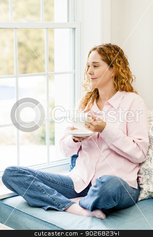 To use this stock image in your creative project, please select the size you need over to the right and click the "Add to Cart" button.
Your downloaded image will come with the Cutcaster watermark removed so don’t worry about the watermark you see on this page. Woman relaxing by the window with coffee stock photo, Smiling caucasian woman relaxing on couch by window holding cup of coffee by Elena Elisseeva