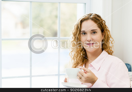 To use this stock image in your creative project, please select the size you need over to the right and click the "Add to Cart" button.
Your downloaded image will come with the Cutcaster watermark removed so don’t worry about the watermark you see on this page. Woman relaxing by the window with beverage stock photo, Smiling caucasian woman relaxing by window holding cup of coffee by Elena Elisseeva