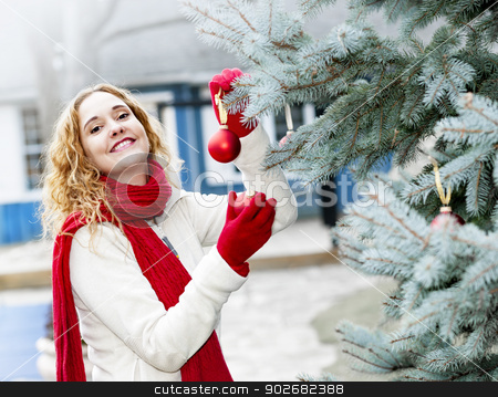 To use this stock image in your creative project, please select the size you need over to the right and click the "Add to Cart" button.
Your downloaded image will come with the Cutcaster watermark removed so don’t worry about the watermark you see on this page. Woman decorating Christmas tree outside stock photo, Joyful woman hanging Christmas ornaments on spruce tree outdoors in yard near home by Elena Elisseeva