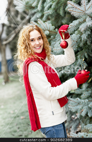 To use this stock image in your creative project, please select the size you need over to the right and click the "Add to Cart" button.
Your downloaded image will come with the Cutcaster watermark removed so don’t worry about the watermark you see on this page. Woman decorating Christmas tree outside stock photo, Joyful woman hanging Christmas ornaments on spruce tree outdoors in yard near home by Elena Elisseeva