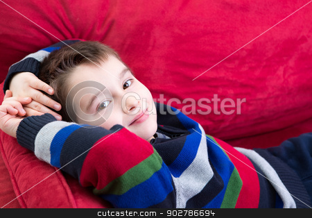 Young Boy On The Red Couch Stock Photo