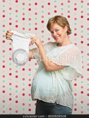 To use this stock image in your creative project, please select the size you need over to the right and click the "Add to Cart" button.
Your downloaded image will come with the Cutcaster watermark removed so don’t worry about the watermark you see on this page. Expecting Mother with Baby Clothes stock photo, Proud young pregnant woman showing off baby clothes by Scott Griessel