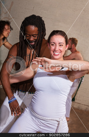 To use this stock image in your creative project, please select the size you need over to the right and click the "Add to Cart" button.
Your downloaded image will come with the Cutcaster watermark removed so don’t worry about the watermark you see on this page. Capoeira Student Laughing with Teacher stock photo, Laughing capoeira performers in urban building by Scott Griessel