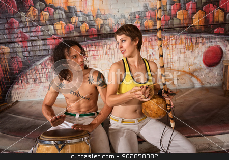To use this stock image in your creative project, please select the size you need over to the right and click the "Add to Cart" button.
Your downloaded image will come with the Cutcaster watermark removed so don’t worry about the watermark you see on this page. Capoeira Couple Playing Traditional Instruments stock photo, Cute young couple in capoeira outfit playing traditional instruments by Scott Griessel
