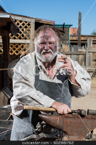 To use this stock image in your creative project, please select the size you need over to the right and click the "Add to Cart" button.
Your downloaded image will come with the Cutcaster watermark removed so don’t worry about the watermark you see on this page. Old West Blacksmith stock photo, Old West Blacksmith Smokes Cigar While Resting Hammer on Anvil by Scott Griessel