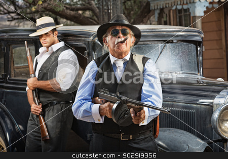 To use this stock image in your creative project, please select the size you need over to the right and click the "Add to Cart" button.
Your downloaded image will come with the Cutcaster watermark removed so don’t worry about the watermark you see on this page. Serious Mob Boss stock photo, Serious mob boss with gun and guard near car by Scott Griessel