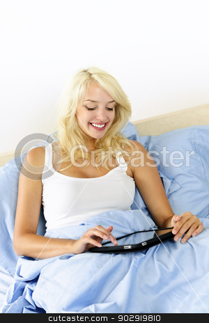 To use this stock image in your creative project, please select the size you need over to the right and click the "Add to Cart" button.
Your downloaded image will come with the Cutcaster watermark removed so don’t worry about the watermark you see on this page. Woman sitting in bed with tablet device stock photo, Happy blonde woman using tablet computer sitting in bed by Elena Elisseeva