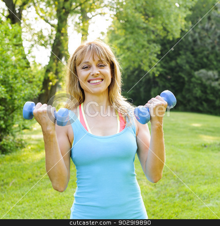To use this stock image in your creative project, please select the size you need over to the right and click the "Add to Cart" button.
Your downloaded image will come with the Cutcaster watermark removed so don’t worry about the watermark you see on this page. Woman exercising with dumbbells stock photo, Portrait of female fitness instructor exercising with small weights in green park by Elena Elisseeva