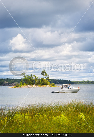 To use this stock image in your creative project, please select the size you need over to the right and click the "Add to Cart" button.
Your downloaded image will come with the Cutcaster watermark removed so don’t worry about the watermark you see on this page. Boat anchored on lake stock photo, Motorboat anchored with dinghy on lake in Georgian Bay, Ontario, Canada by Elena Elisseeva
