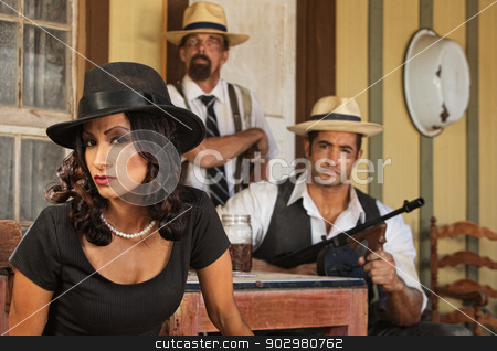 To use this stock image in your creative project, please select the size you need over to the right and click the "Add to Cart" button.
Your downloaded image will come with the Cutcaster watermark removed so don’t worry about the watermark you see on this page. 1920s Era Bootleggers stock photo, Serious gangster woman with bootleggers at table by Scott Griessel