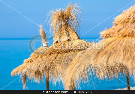 To use this stock image in your creative project, please select the size you need over to the right and click the "Add to Cart" button.
Your downloaded image will come with the Cutcaster watermark removed so don’t worry about the watermark you see on this page. Straw umbrella hats stock photo, Yellow straw umbrella hats against blue sky-water background. Focus on the central hat by Natalia Macheda
