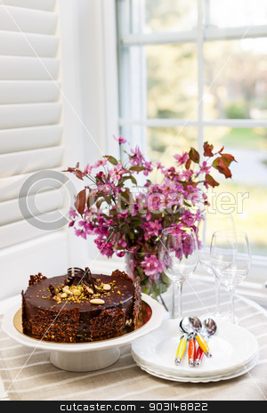 To use this stock image in your creative project, please select the size you need over to the right and click the "Add to Cart" button.
Your downloaded image will come with the Cutcaster watermark removed so don’t worry about the watermark you see on this page. Chocolate cake stock photo, Round gourmet chocolate cake on table next to window with plates, cutlery, and pink spring bouquet by Elena Elisseeva