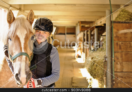To use this stock image in your creative project, please select the size you need over to the right and click the "Add to Cart" button.
Your downloaded image will come with the Cutcaster watermark removed so don’t worry about the watermark you see on this page. Rider with horse in stable stock photo, Young female rider with horse inside stable by Elena Elisseeva