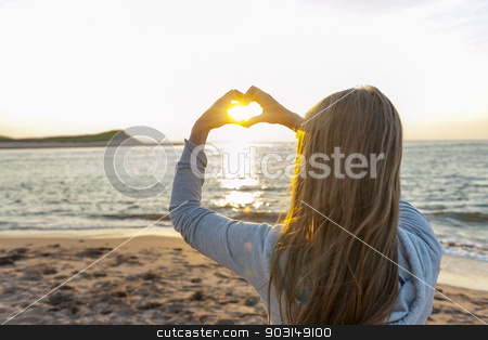 To use this stock image in your creative project, please select the size you need over to the right and click the "Add to Cart" button.
Your downloaded image will come with the Cutcaster watermark removed so don’t worry about the watermark you see on this page. Girl holding hands in heart shape at beach stock photo, Blonde young girl holding hands in heart shape framing setting sun at sunset on ocean beach by Elena Elisseeva