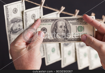 To use this stock image in your creative project, please select the size you need over to the right and click the "Add to Cart" button.
Your downloaded image will come with the Cutcaster watermark removed so don’t worry about the watermark you see on this page. Male Holding Hundred Dollar Bills, Many Handing from Clothesline stock photo, Male Hands Holding Hundred Dollar Bills with Several Hanging From a Clothesline on a Dark Background. by Andy Dean