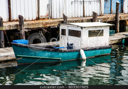 To use this stock image in your creative project, please select the size you need over to the right and click the "Add to Cart" button.
Your downloaded image will come with the Cutcaster watermark removed so don’t worry about the watermark you see on this page. Old Blue and White Fishing Boat stock photo, An old wood fishing boat in a harbor by Darryl Brooks