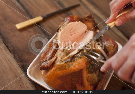 To use this stock image in your creative project, please select the size you need over to the right and click the "Add to Cart" button.
Your downloaded image will come with the Cutcaster watermark removed so don’t worry about the watermark you see on this page. Man carving a roast turkey stock photo, Overhead view of the hands of a man carving a roast turkey with a carving knife and fork slicing the breast meat ready for a Thanksgiving or Christmas dinner by Stephen Gibson