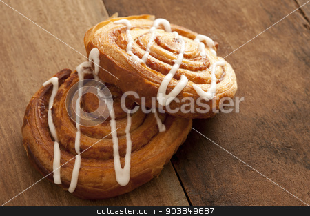 To use this stock image in your creative project, please select the size you need over to the right and click the "Add to Cart" button.
Your downloaded image will come with the Cutcaster watermark removed so don’t worry about the watermark you see on this page. Two delicious freshly baked Danish pastries stock photo, Two delicious freshly baked Danish pastries filled with apple or almond and drizzled with white icing on a rustic wooden kitchen counter ready for a tasty teatime snack by Stephen Gibson