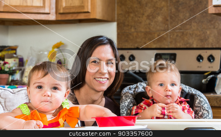 To use this stock image in your creative project, please select the size you need over to the right and click the "Add to Cart" button.
Your downloaded image will come with the Cutcaster watermark removed so don’t worry about the watermark you see on this page. Mother Smiles With Babies stock photo, A mother in the kitchen poses with babies by Scott Griessel