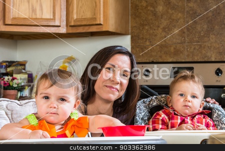 To use this stock image in your creative project, please select the size you need over to the right and click the "Add to Cart" button.
Your downloaded image will come with the Cutcaster watermark removed so don’t worry about the watermark you see on this page. Mother Smiles With Babies stock photo, A mother in the kitchen poses with babies by Scott Griessel
