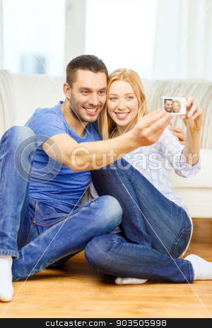 To use this stock image in your creative project, please select the size you need over to the right and click the "Add to Cart" button.
Your downloaded image will come with the Cutcaster watermark removed so don’t worry about the watermark you see on this page. smiling couple taking picture with digital camera stock photo, love, family, technology and happiness concept - smiling couple taking self portrait picture with digital camera at home by Syda Productions