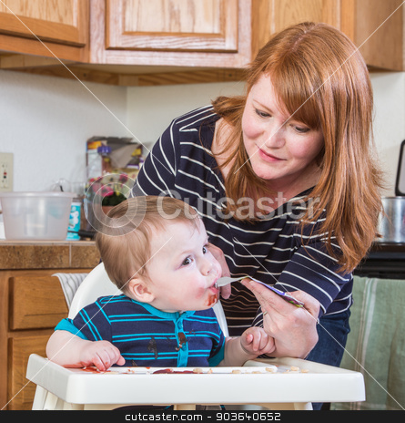To use this stock image in your creative project, please select the size you need over to the right and click the "Add to Cart" button.
Your downloaded image will come with the Cutcaster watermark removed so don’t worry about the watermark you see on this page. Woman Feeds Baby in Kitchen stock photo, A woman feeds her baby juice in the kitchen by Scott Griessel