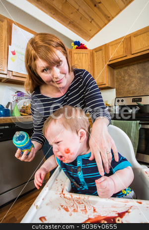 To use this stock image in your creative project, please select the size you need over to the right and click the "Add to Cart" button.
Your downloaded image will come with the Cutcaster watermark removed so don’t worry about the watermark you see on this page. Woman Feeds Her Gumpy Baby stock photo, Grumpy baby in kitchen is being fed from her bottle by Scott Griessel