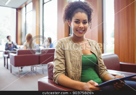 To use this stock image in your creative project, please select the size you need over to the right and click the "Add to Cart" button.
Your downloaded image will come with the Cutcaster watermark removed so don’t worry about the watermark you see on this page. Student sitting on sofa using her tablet pc smiling at camera stock photo, Student sitting on sofa using her tablet pc smiling at camera at the university by Wavebreak Media