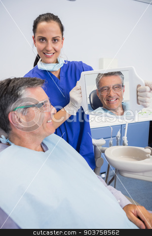 To use this stock image in your creative project, please select the size you need over to the right and click the "Add to Cart" button.
Your downloaded image will come with the Cutcaster watermark removed so don’t worry about the watermark you see on this page. Smiling dentist showing teeth of her patient with a mirror stock photo, Smiling dentist showing teeth of her patient with a mirror in dental clinic by Wavebreak Media