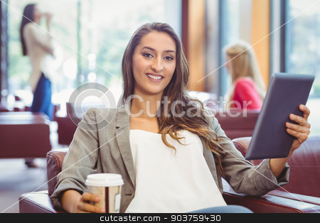 To use this stock image in your creative project, please select the size you need over to the right and click the "Add to Cart" button.
Your downloaded image will come with the Cutcaster watermark removed so don’t worry about the watermark you see on this page. Smiling girl using digital tablet and holding disposable cup stock photo, Smiling girl using digital tablet and holding disposable cup in library by Wavebreak Media