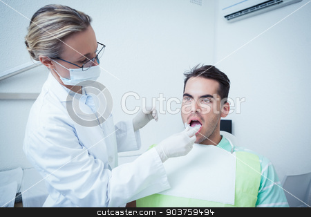 To use this stock image in your creative project, please select the size you need over to the right and click the "Add to Cart" button.
Your downloaded image will come with the Cutcaster watermark removed so don’t worry about the watermark you see on this page. Female dentist examining mans teeth stock photo, Female dentist examining mans teeth in the dentists chair by Wavebreak Media