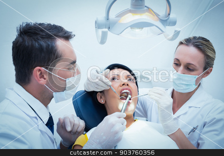 To use this stock image in your creative project, please select the size you need over to the right and click the "Add to Cart" button.
Your downloaded image will come with the Cutcaster watermark removed so don’t worry about the watermark you see on this page. Male dentist with assistant examining womans teeth stock photo, Male dentist with assistant examining womans teeth in the dentists chair by Wavebreak Media