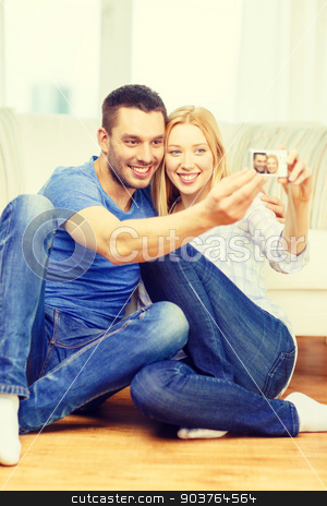 To use this stock image in your creative project, please select the size you need over to the right and click the "Add to Cart" button.
Your downloaded image will come with the Cutcaster watermark removed so don’t worry about the watermark you see on this page. smiling couple taking picture with digital camera stock photo, love, family, technology and happiness concept - smiling couple taking self portrait picture with digital camera at home by Syda Productions