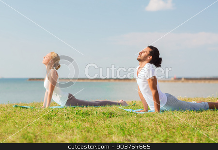 To use this stock image in your creative project, please select the size you need over to the right and click the "Add to Cart" button.
Your downloaded image will come with the Cutcaster watermark removed so don’t worry about the watermark you see on this page. smiling couple making yoga exercises outdoors stock photo, fitness, sport, friendship and lifestyle concept - smiling couple making yoga exercises lying on mats outdoors by Syda Productions