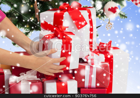 To use this stock image in your creative project, please select the size you need over to the right and click the "Add to Cart" button.
Your downloaded image will come with the Cutcaster watermark removed so don’t worry about the watermark you see on this page. close up of woman with gifts and christmas tree stock photo, winter holidays, celebration and people concept - close up of woman putting present under christmas tree over blue background with snow by Syda Productions