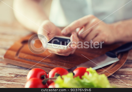 To use this stock image in your creative project, please select the size you need over to the right and click the "Add to Cart" button.
Your downloaded image will come with the Cutcaster watermark removed so don’t worry about the watermark you see on this page. closeup of man pointing finger to smartphone stock photo, cooking, technology and home concept - closeup of man pointing finger to smartphone by Syda Productions