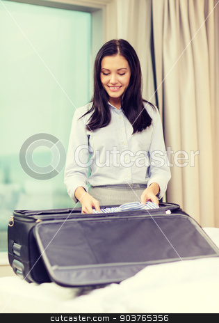 To use this stock image in your creative project, please select the size you need over to the right and click the "Add to Cart" button.
Your downloaded image will come with the Cutcaster watermark removed so don’t worry about the watermark you see on this page. businesswoman packing things in suitcase stock photo, business, technology, internet and hotel concept - happy businesswoman packing things in suitcase in hotel room by Syda Productions