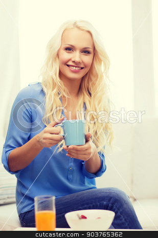 To use this stock image in your creative project, please select the size you need over to the right and click the "Add to Cart" button.
Your downloaded image will come with the Cutcaster watermark removed so don’t worry about the watermark you see on this page. smiling woman with cup of tea having breakfast stock photo, healthcare, food, home and happiness concept - smiling woman with cup of tea, glass of juice and bowl of muesli having breakfast by Syda Productions